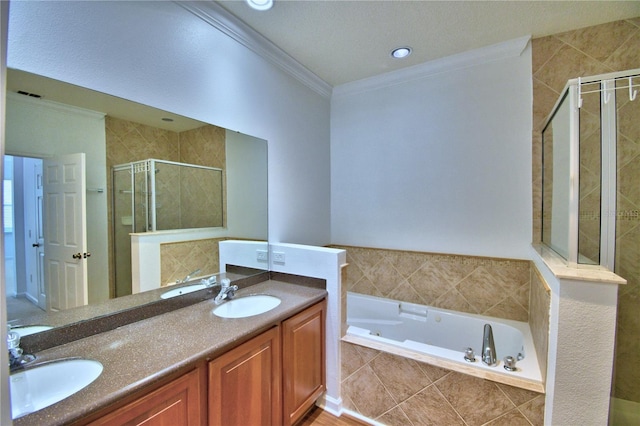 bathroom with a shower stall, double vanity, a sink, and crown molding