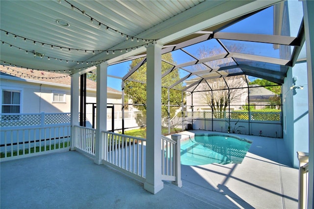 view of pool with a fenced in pool, glass enclosure, and a patio area