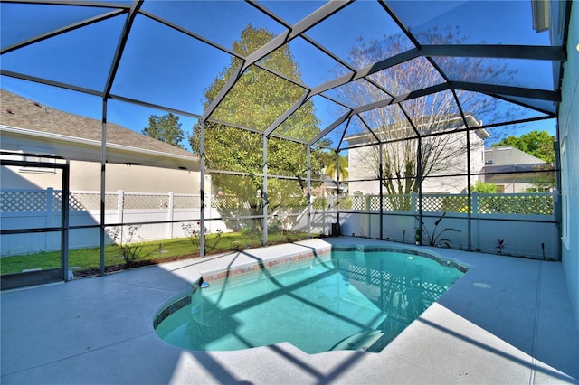 view of swimming pool with glass enclosure, a patio area, a fenced backyard, and a fenced in pool