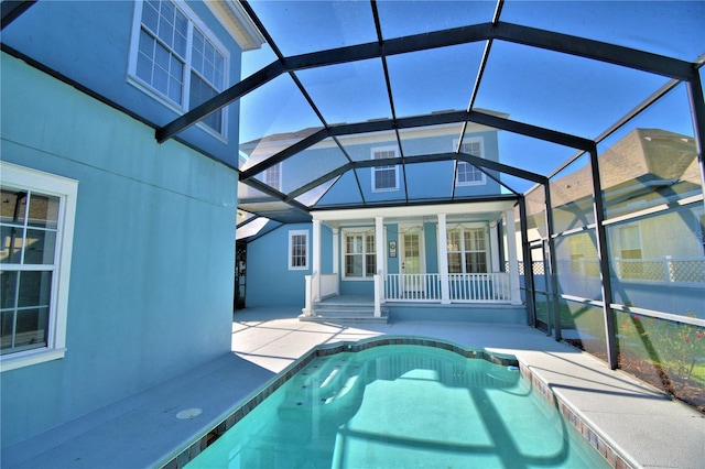 pool with glass enclosure, a patio area, and fence