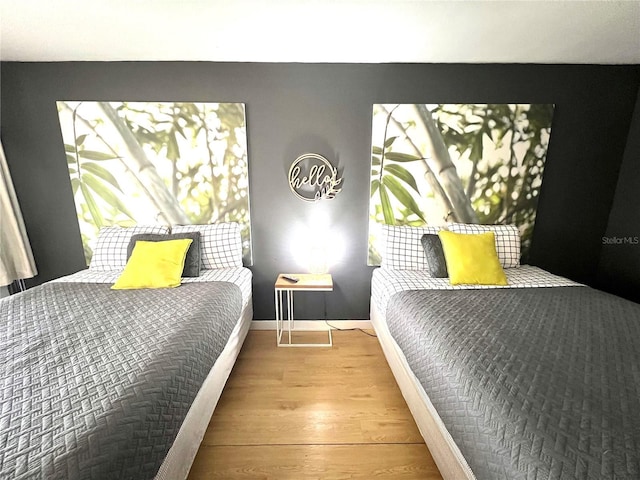 bedroom featuring wood finished floors and baseboards