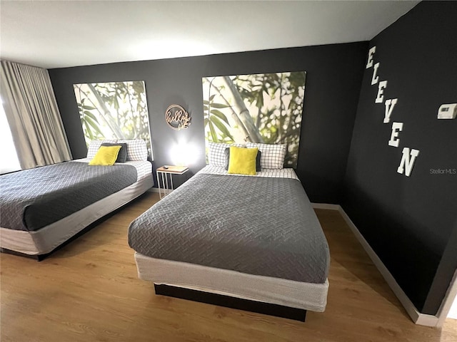 bedroom with baseboards and wood finished floors