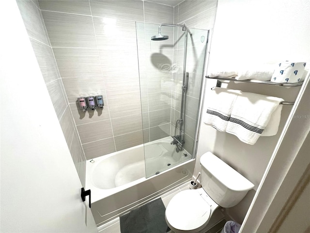 bathroom with enclosed tub / shower combo and toilet