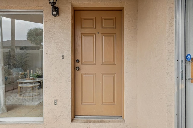 doorway to property featuring stucco siding