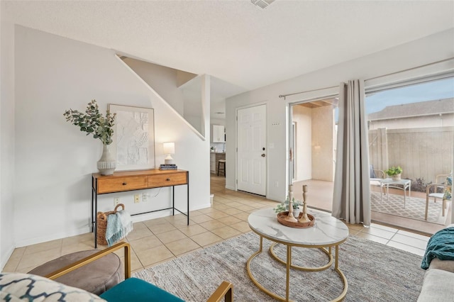 living room with tile patterned floors, a textured ceiling, and baseboards