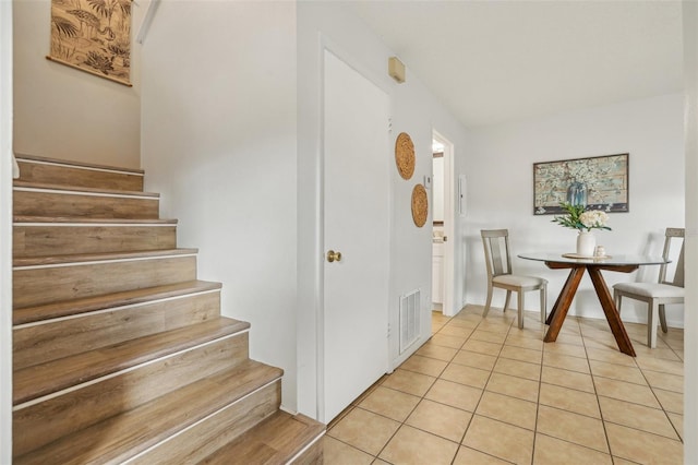 staircase featuring tile patterned floors and visible vents