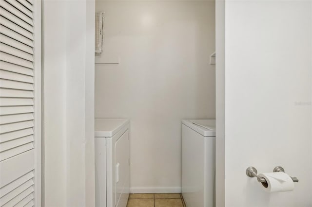 washroom with washer and dryer, baseboards, laundry area, and light tile patterned floors