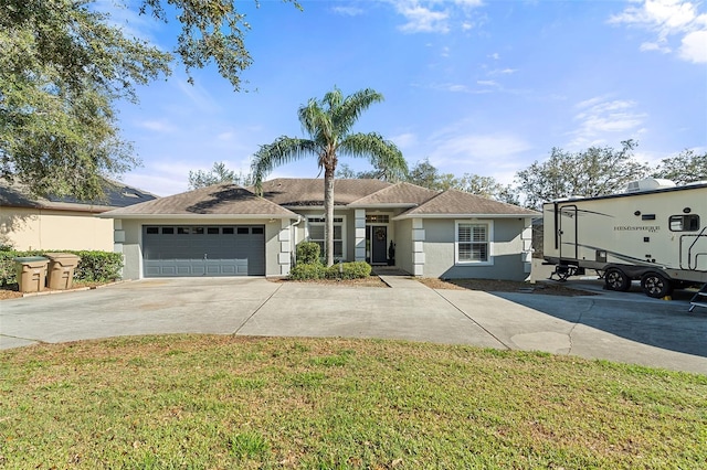 ranch-style house featuring a garage, a front yard, driveway, and stucco siding