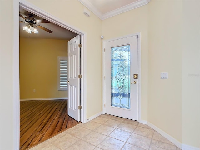 foyer entrance with light tile patterned floors, ornamental molding, a ceiling fan, and baseboards