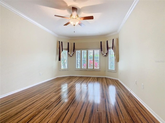 empty room with ornamental molding, a ceiling fan, baseboards, and wood finished floors