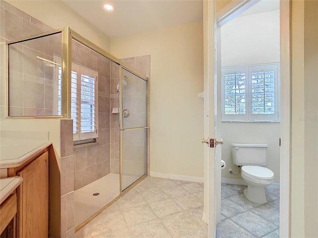 bathroom with recessed lighting, toilet, a shower stall, vanity, and baseboards