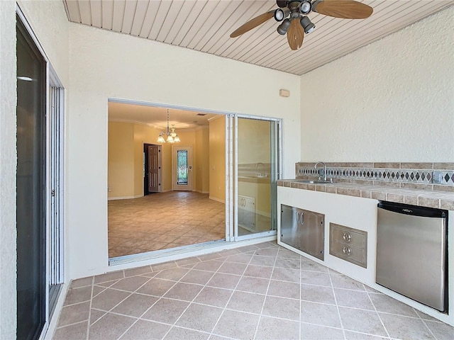 view of patio featuring a ceiling fan, a sink, and an outdoor kitchen