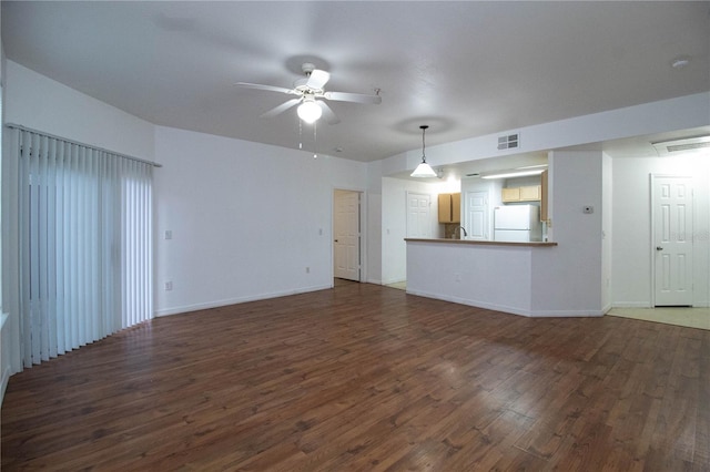 unfurnished living room featuring ceiling fan, dark wood-type flooring, visible vents, and baseboards