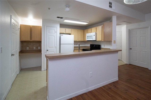 kitchen featuring white appliances, visible vents, a peninsula, light countertops, and light brown cabinetry