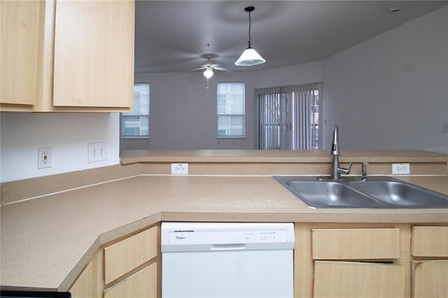 kitchen with light brown cabinetry, white dishwasher, and a sink