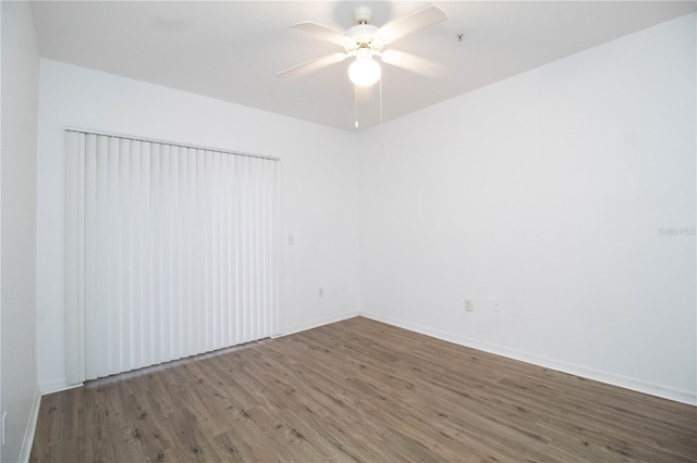 unfurnished room with ceiling fan, dark wood-style flooring, and baseboards