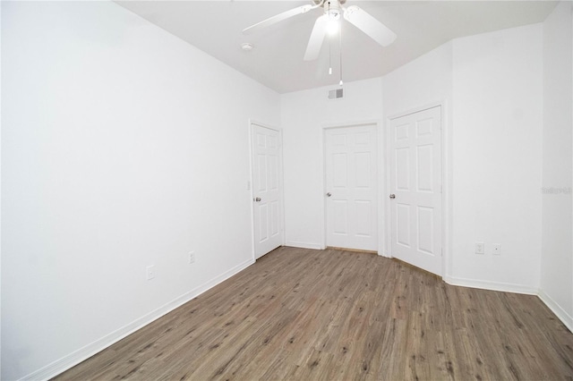 interior space featuring visible vents, ceiling fan, baseboards, and wood finished floors