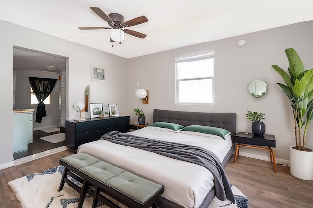 bedroom featuring dark wood finished floors, a ceiling fan, and baseboards