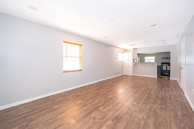 unfurnished living room featuring wood finished floors and baseboards