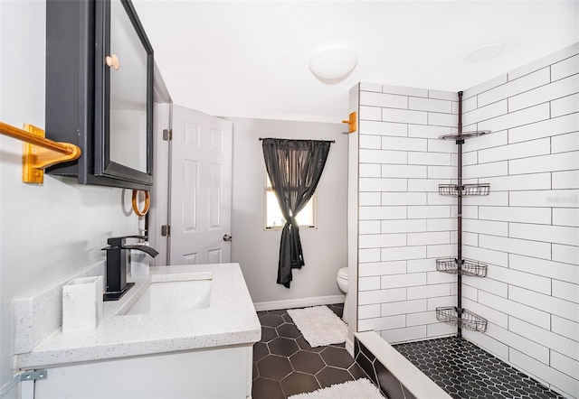 bathroom with a shower stall, baseboards, vanity, and toilet