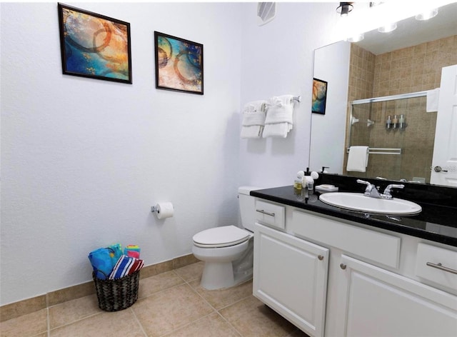 bathroom with baseboards, toilet, tile patterned floors, vanity, and a shower stall