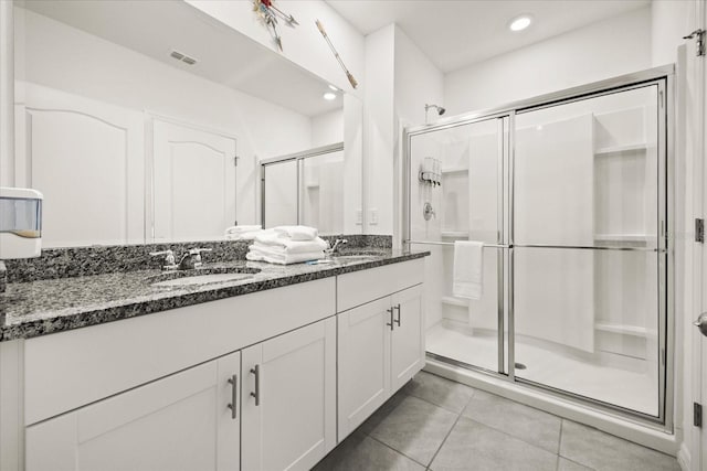 bathroom featuring tile patterned flooring, vanity, and walk in shower