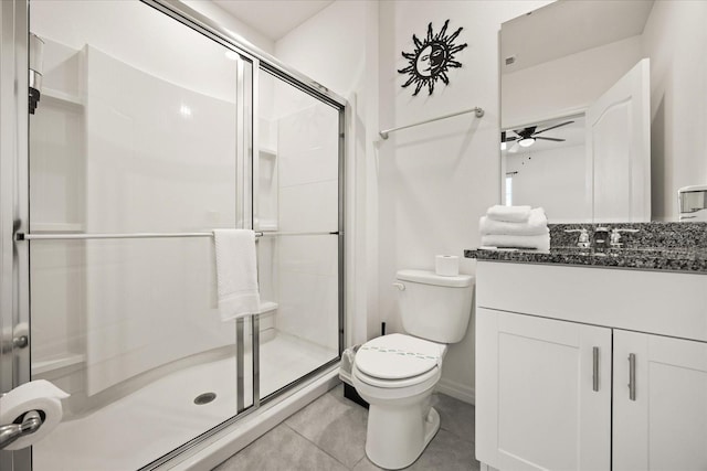 bathroom featuring tile patterned floors, toilet, vanity, and a shower with shower door