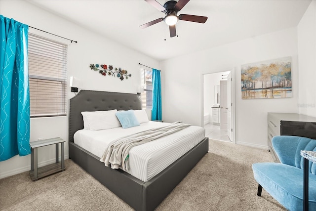 bedroom with light carpet, ceiling fan, and ensuite bath