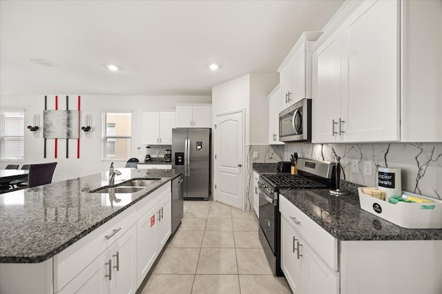 kitchen featuring sink, appliances with stainless steel finishes, white cabinetry, and an island with sink