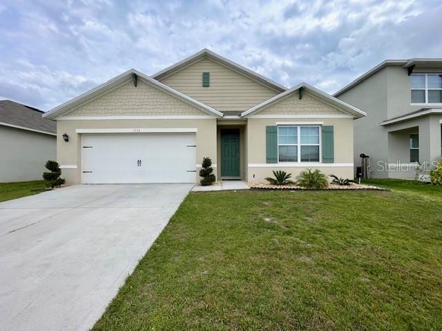 view of front of house featuring a garage, concrete driveway, a front yard, and stucco siding