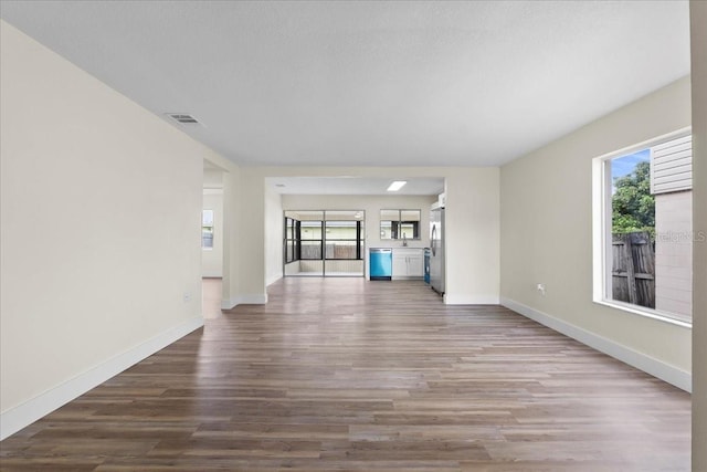 unfurnished living room with visible vents, baseboards, and wood finished floors