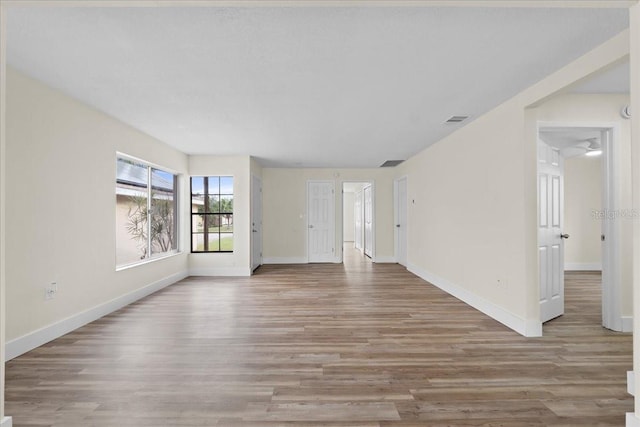 unfurnished living room featuring baseboards and wood finished floors