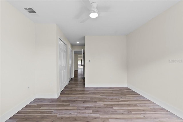 empty room with visible vents, a ceiling fan, wood finished floors, recessed lighting, and baseboards