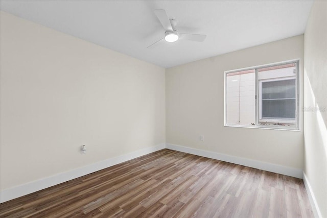 unfurnished room with ceiling fan, baseboards, and wood finished floors