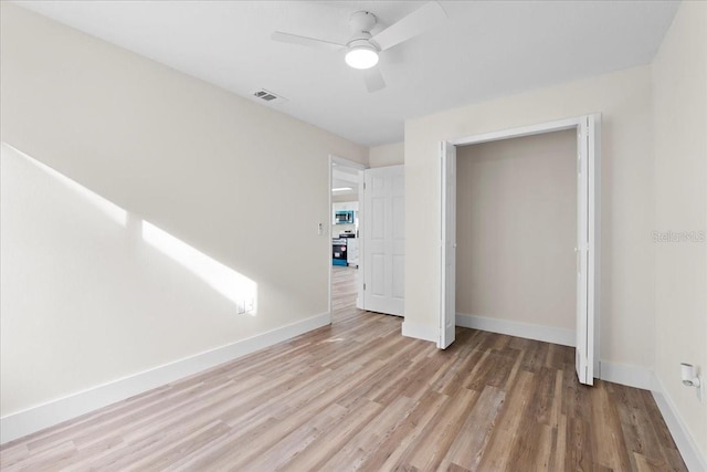 unfurnished bedroom featuring a ceiling fan, wood finished floors, visible vents, and baseboards