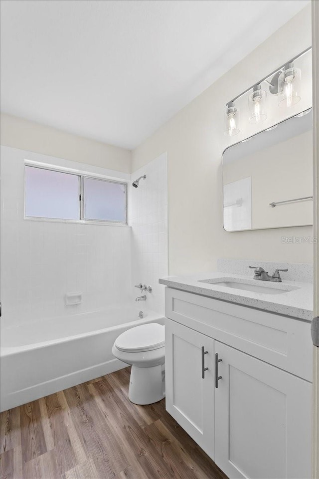 full bathroom featuring vanity, bathing tub / shower combination, toilet, and wood finished floors