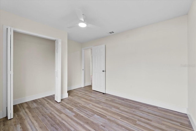 unfurnished bedroom with visible vents, a ceiling fan, a closet, light wood finished floors, and baseboards