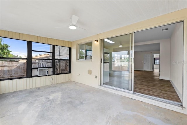 unfurnished sunroom with cooling unit, visible vents, and ceiling fan