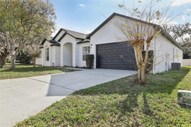 ranch-style home featuring a front yard, a garage, and central AC unit
