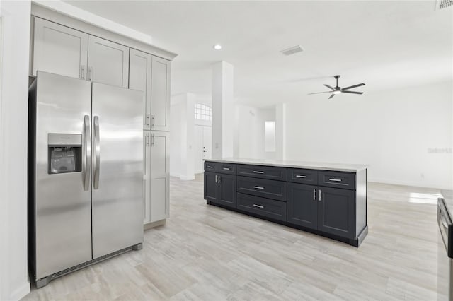kitchen featuring stainless steel refrigerator with ice dispenser, a kitchen island, light hardwood / wood-style floors, ceiling fan, and gray cabinets