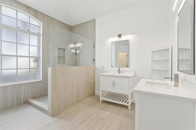 bathroom featuring tiled shower and vanity