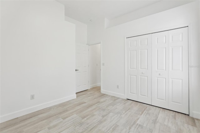 unfurnished bedroom featuring light hardwood / wood-style floors and a closet