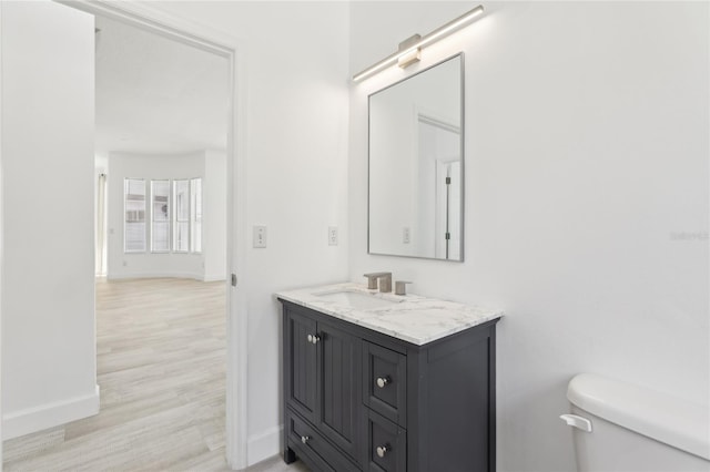 bathroom featuring hardwood / wood-style flooring, toilet, and vanity