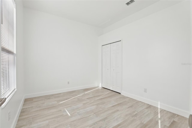 unfurnished bedroom featuring light hardwood / wood-style flooring and a closet
