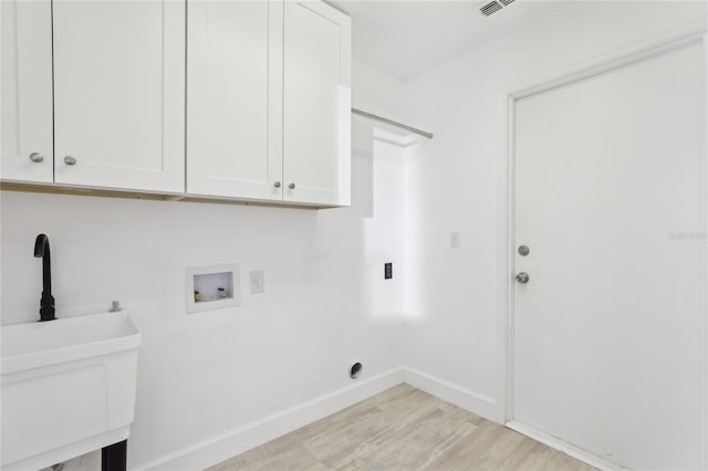 washroom featuring sink, cabinets, hookup for a washing machine, and light hardwood / wood-style flooring