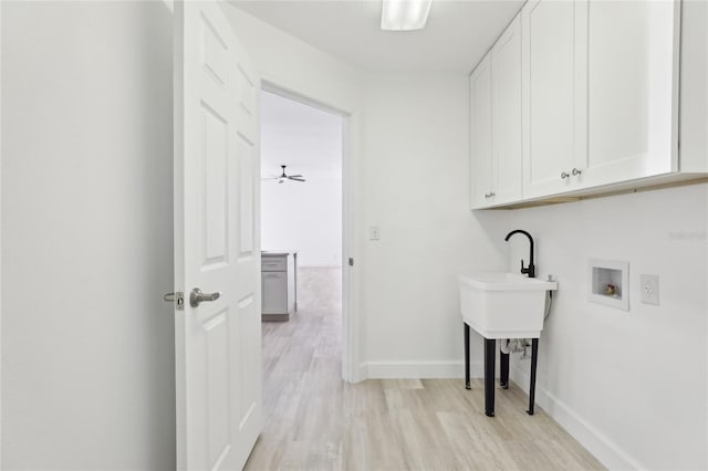 laundry area with cabinets, hookup for a washing machine, and light hardwood / wood-style flooring