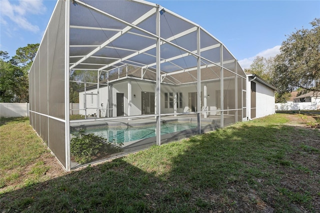 view of swimming pool featuring a patio area, a yard, and glass enclosure