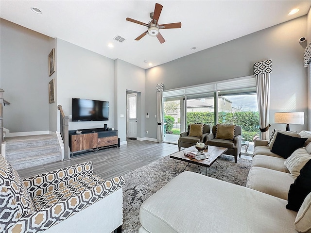 living room with baseboards, visible vents, ceiling fan, a high ceiling, and recessed lighting