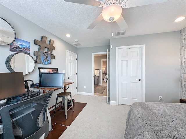 bedroom with baseboards, visible vents, ceiling fan, carpet, and a textured ceiling