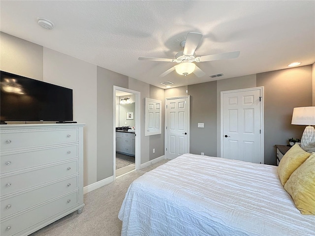 bedroom with light carpet, baseboards, visible vents, and connected bathroom